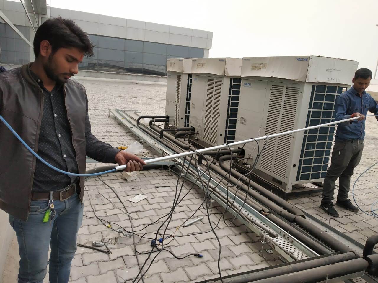 Technician maintaining outdoor HVAC equipment